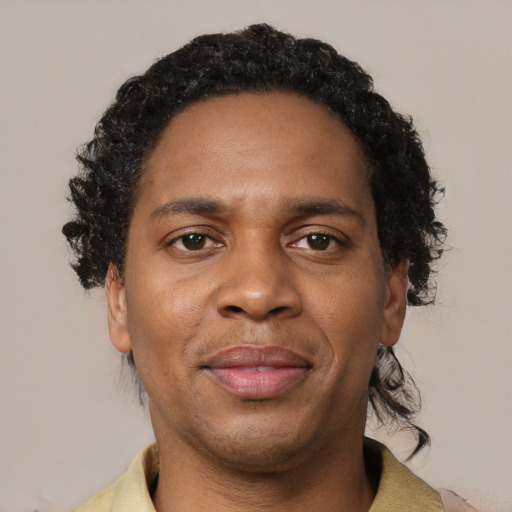 Joyful black young-adult male with short  brown hair and brown eyes