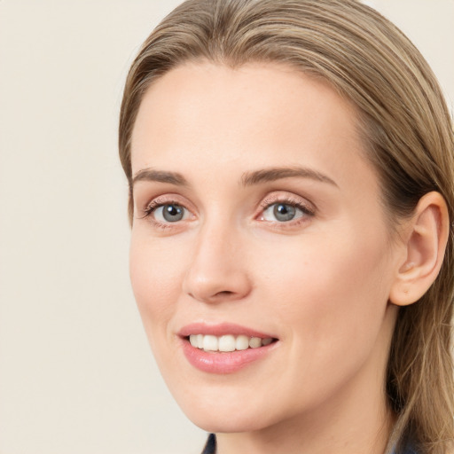 Joyful white young-adult female with long  brown hair and blue eyes