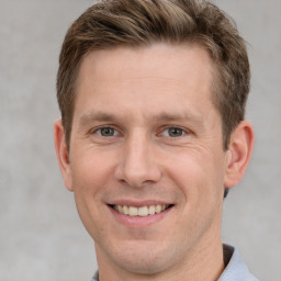 Joyful white adult male with short  brown hair and grey eyes