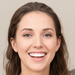 Joyful white young-adult female with long  brown hair and green eyes