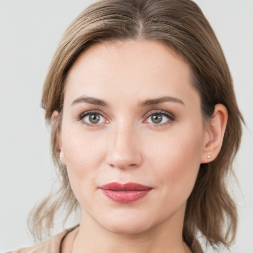 Joyful white young-adult female with medium  brown hair and grey eyes