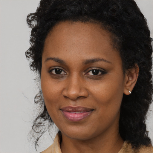 Joyful black young-adult female with long  brown hair and brown eyes