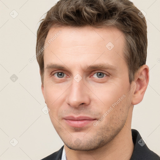 Joyful white young-adult male with short  brown hair and grey eyes