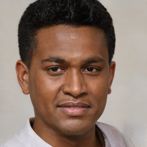 Joyful black young-adult male with short  brown hair and brown eyes