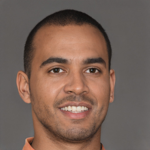 Joyful latino young-adult male with short  brown hair and brown eyes