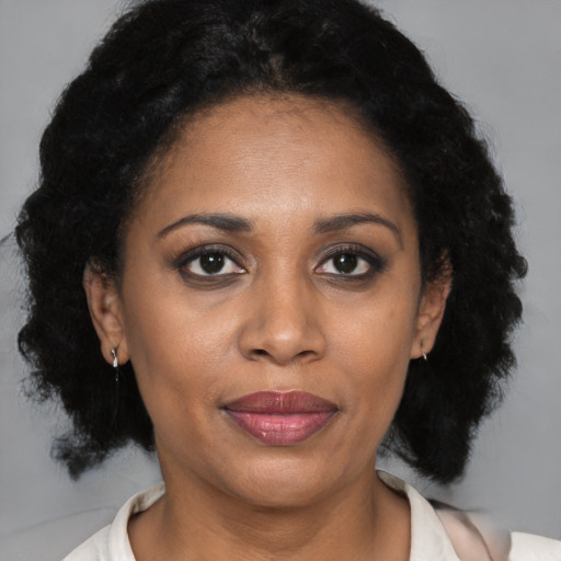 Joyful black adult female with medium  brown hair and brown eyes