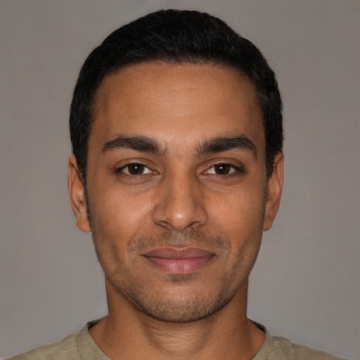 Joyful latino young-adult male with short  black hair and brown eyes