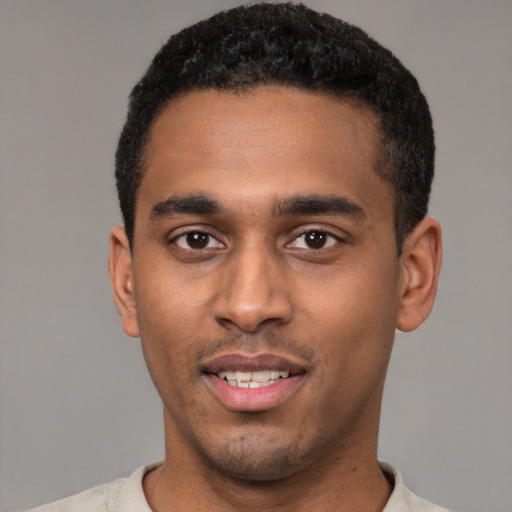 Joyful black young-adult male with short  black hair and brown eyes