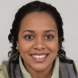 Joyful black young-adult female with long  brown hair and brown eyes