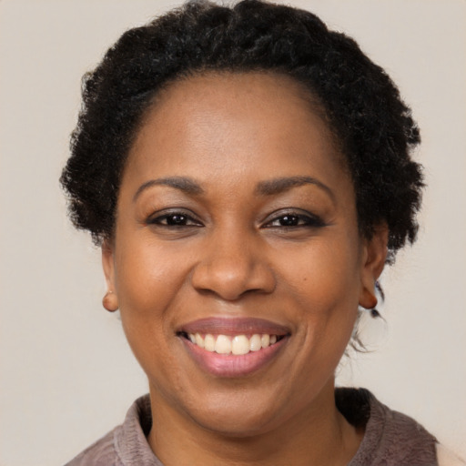 Joyful black adult female with short  brown hair and brown eyes