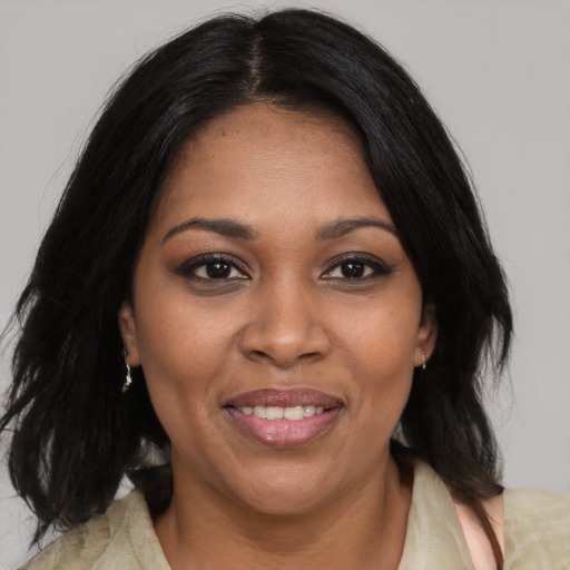 Joyful black adult female with medium  black hair and brown eyes