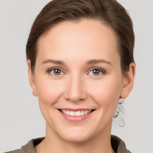 Joyful white young-adult female with short  brown hair and grey eyes