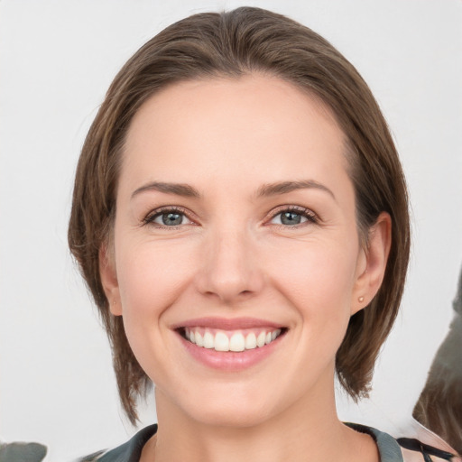 Joyful white young-adult female with medium  brown hair and grey eyes