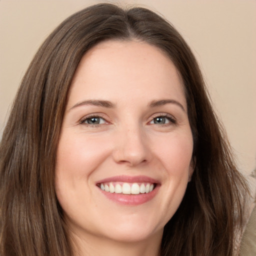 Joyful white young-adult female with long  brown hair and brown eyes