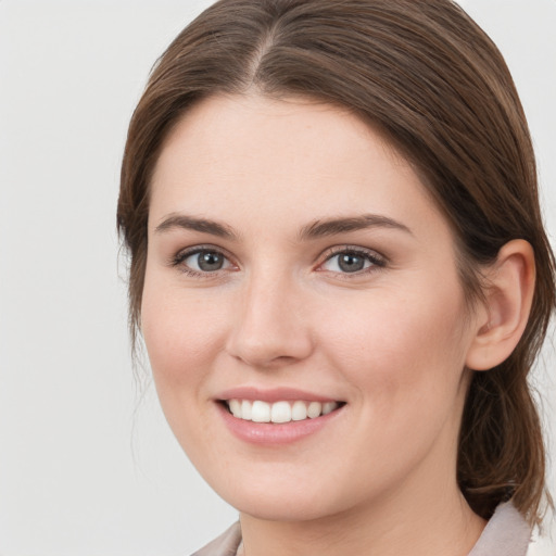 Joyful white young-adult female with medium  brown hair and grey eyes