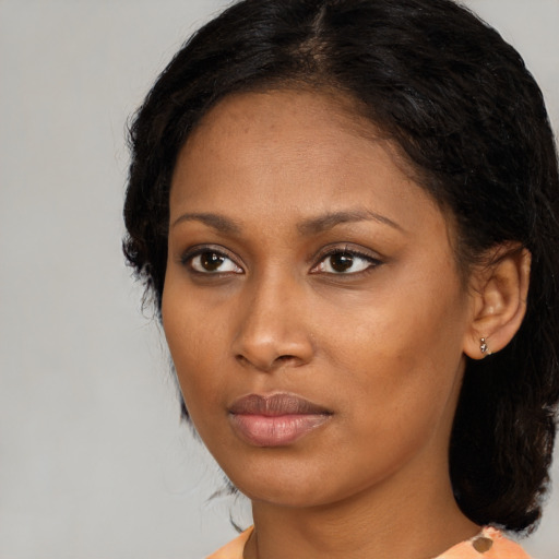 Joyful black young-adult female with medium  brown hair and brown eyes