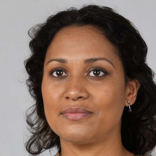 Joyful black adult female with medium  brown hair and brown eyes