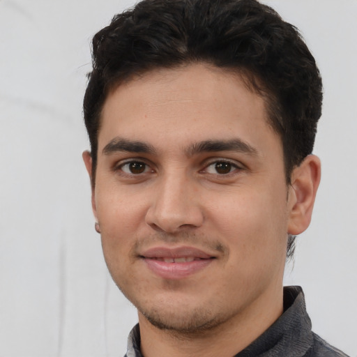 Joyful white young-adult male with short  black hair and brown eyes