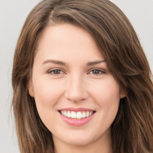 Joyful white young-adult female with long  brown hair and green eyes