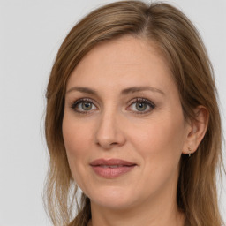 Joyful white adult female with long  brown hair and grey eyes