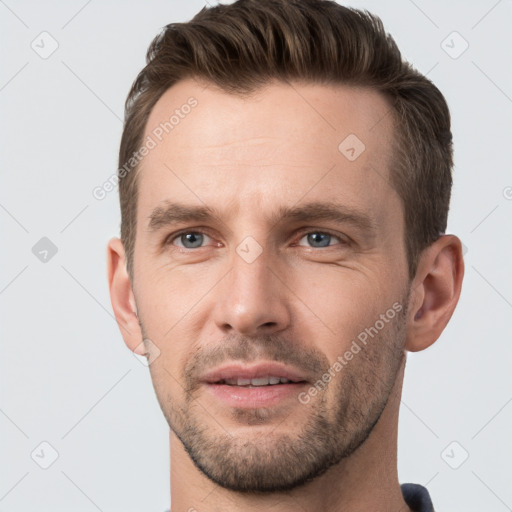 Joyful white young-adult male with short  brown hair and grey eyes