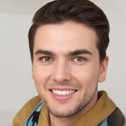 Joyful white young-adult male with short  brown hair and grey eyes