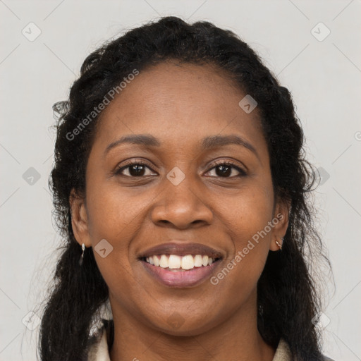 Joyful black young-adult female with long  brown hair and brown eyes