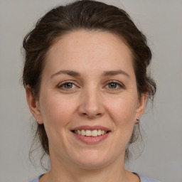 Joyful white adult female with medium  brown hair and grey eyes