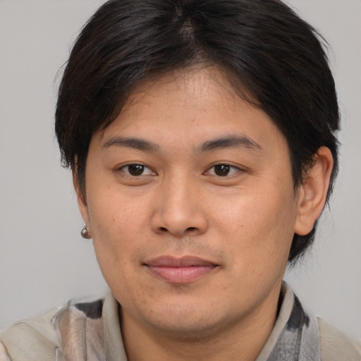 Joyful asian young-adult male with medium  brown hair and brown eyes