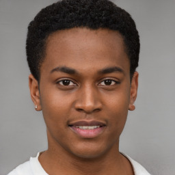 Joyful black young-adult male with short  brown hair and brown eyes