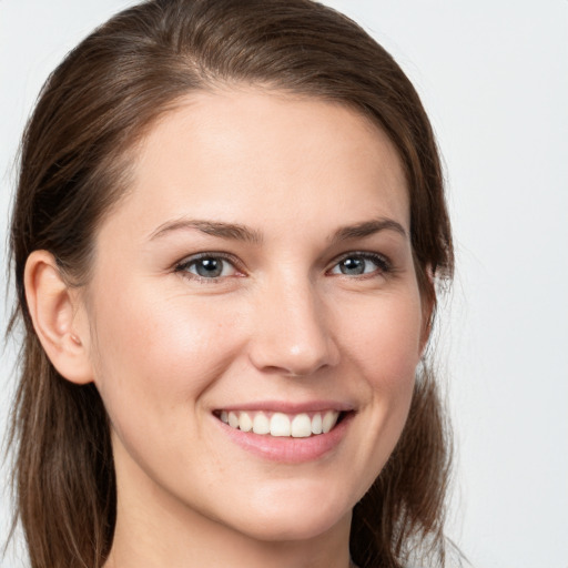 Joyful white young-adult female with long  brown hair and grey eyes