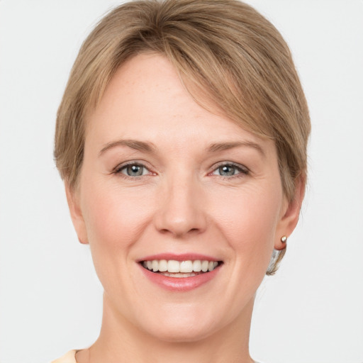 Joyful white young-adult female with short  brown hair and grey eyes