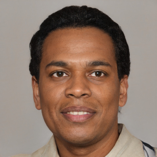 Joyful black adult male with short  black hair and brown eyes