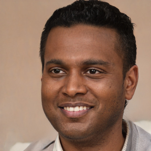 Joyful black young-adult male with short  brown hair and brown eyes