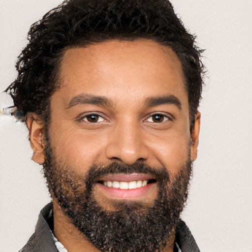 Joyful black young-adult male with short  black hair and brown eyes