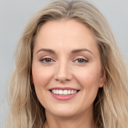 Joyful white young-adult female with long  brown hair and grey eyes