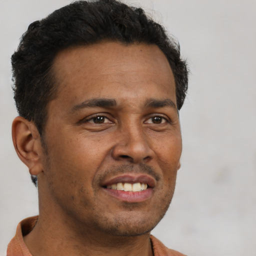 Joyful black young-adult male with short  brown hair and brown eyes