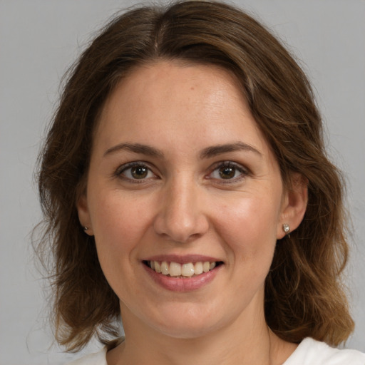 Joyful white young-adult female with medium  brown hair and green eyes