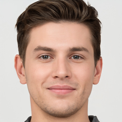 Joyful white young-adult male with short  brown hair and grey eyes