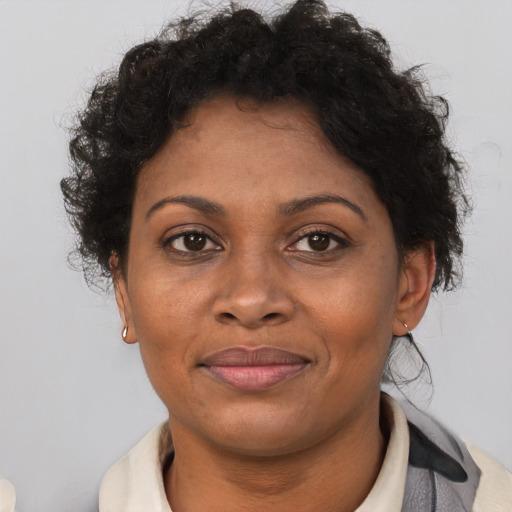 Joyful black adult female with short  brown hair and brown eyes