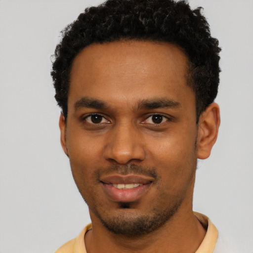 Joyful black young-adult male with short  black hair and brown eyes