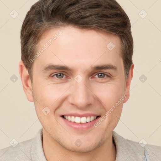 Joyful white young-adult male with short  brown hair and grey eyes