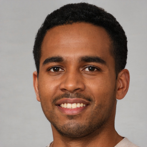 Joyful black young-adult male with short  black hair and brown eyes