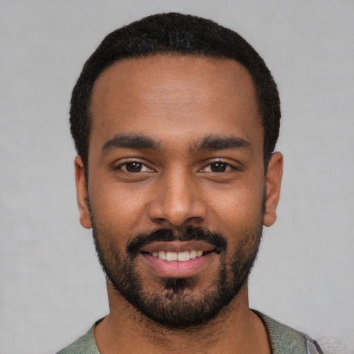 Joyful black young-adult male with short  black hair and brown eyes