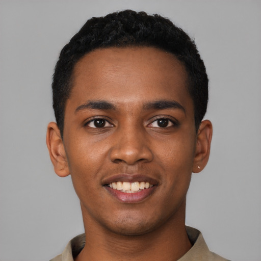 Joyful black young-adult male with short  black hair and brown eyes