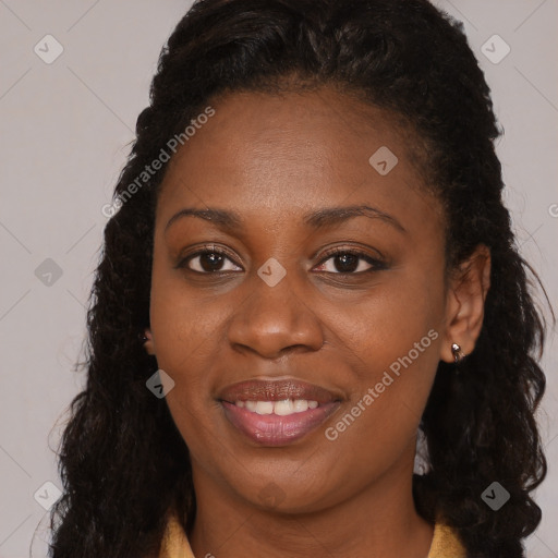 Joyful black young-adult female with long  brown hair and brown eyes