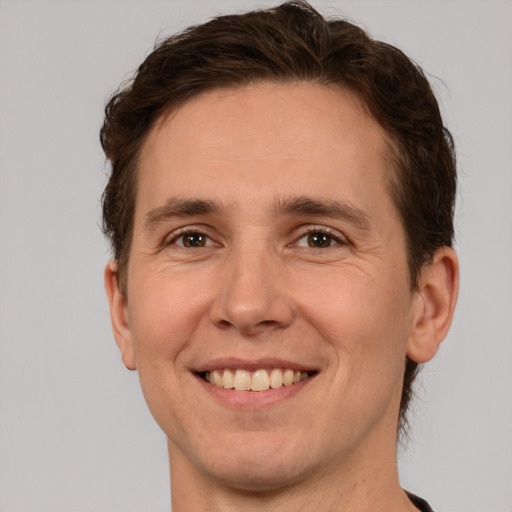 Joyful white young-adult male with short  brown hair and green eyes