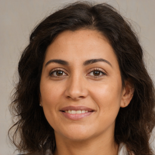 Joyful white adult female with long  brown hair and brown eyes