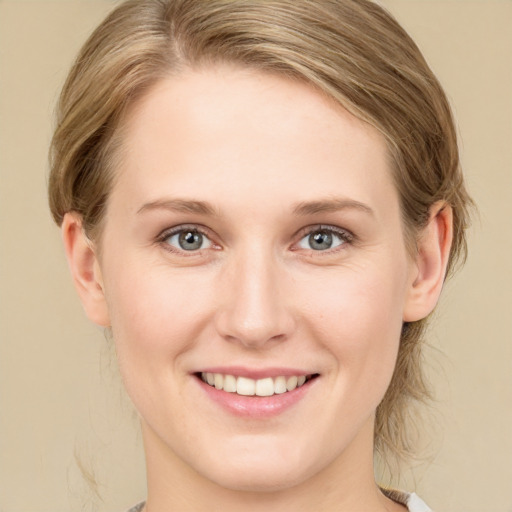 Joyful white young-adult female with medium  brown hair and green eyes