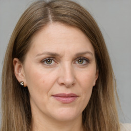 Joyful white adult female with long  brown hair and grey eyes